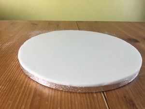 covering a cake board with fondant